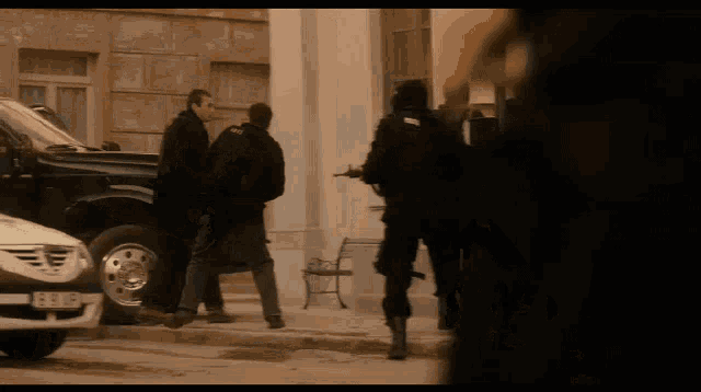 a man in a black coat is walking in front of a black truck