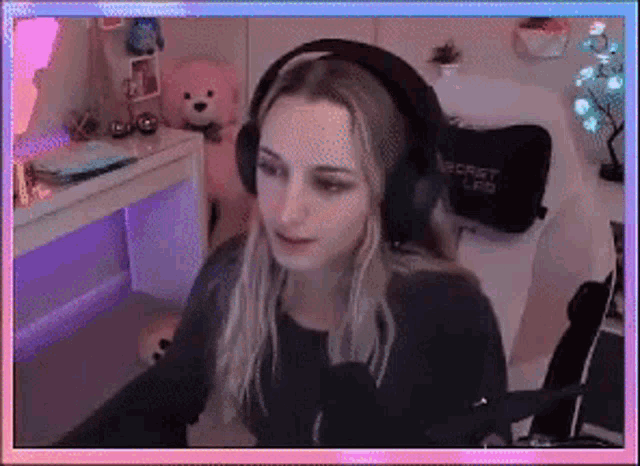 a woman wearing headphones is sitting at a desk in front of a microphone .