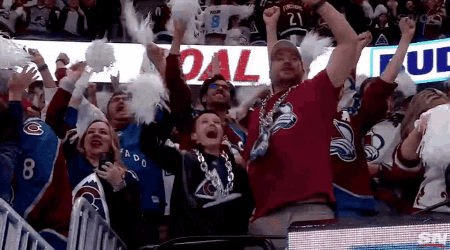 a crowd of people cheering in front of a sign that says " goal "