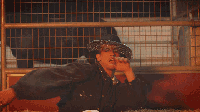 a man wearing a cowboy hat and a veil is giving the middle finger