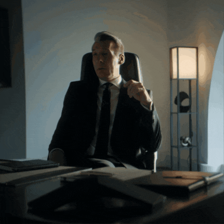 a man in a suit and tie is sitting in a chair