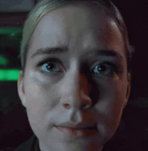 a close up of a woman 's face with a dark background