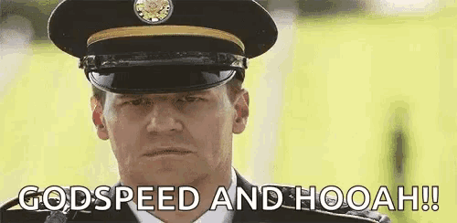 a man in a military uniform is standing in front of a field and says `` godspeed and hooah '' .