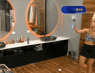 a woman is spraying something in a bathroom with a sign that says i 360 playsite.com