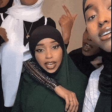 a group of women are posing for a picture with one wearing a hijab