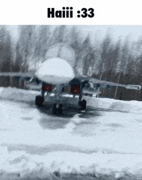 a fighter jet is flying over a snowy field .