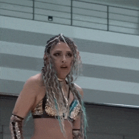a woman wearing a braided top is covering her face