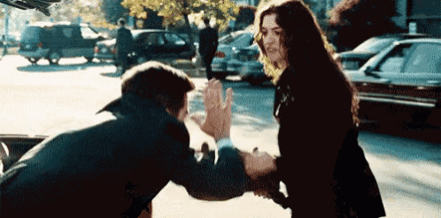 a man and a woman are standing next to each other on a street .
