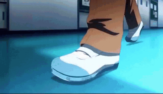 a close up of a person 's foot wearing white shoes walking on a blue floor .