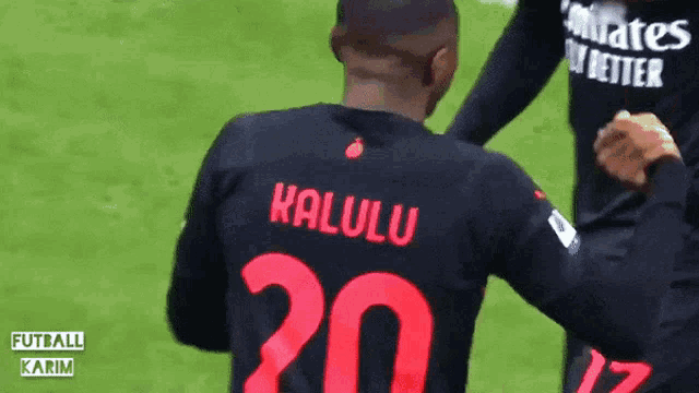a man wearing a black shirt with the number 20 on the back