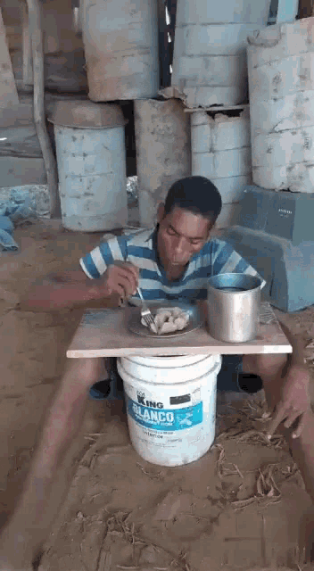 a man is eating from a white bucket that says king blanco