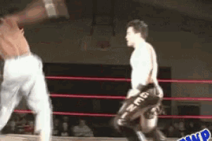 two men are wrestling in a ring and one of them is wearing a pair of shorts with the word nmb on them