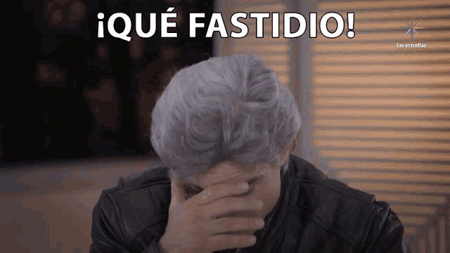a man with gray hair is covering his face with his hand and the words ique fastidio are above him