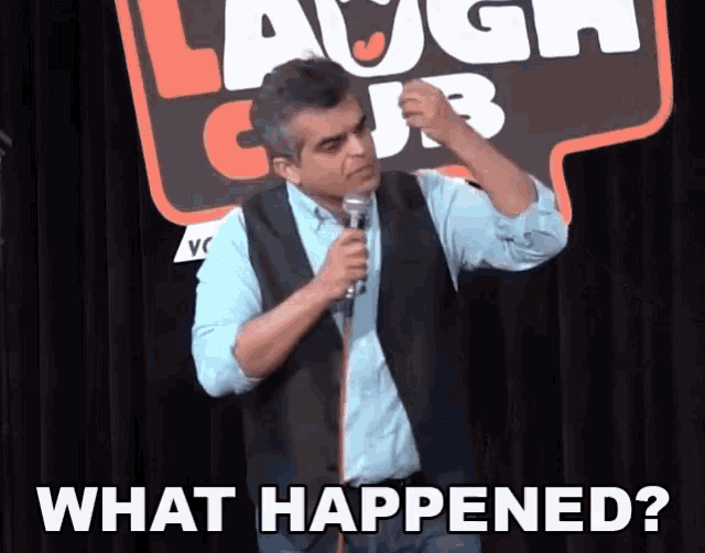 a man is holding a microphone in front of a sign that says laugh club