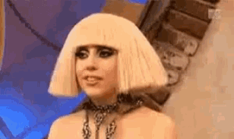 a close up of a woman wearing a blonde wig and a black choker .
