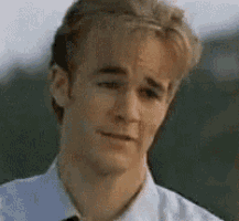 a young man in a white shirt and tie is looking at the camera .