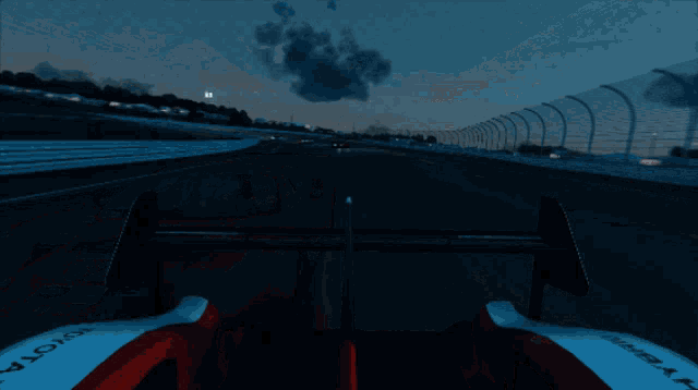 a toyota race car is driving down a race track at night