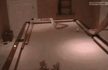 a man is playing pool in a room with a pool table and cues .