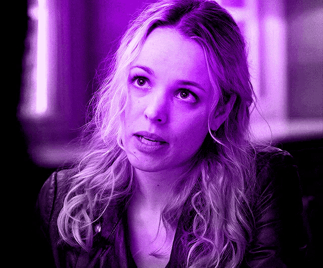 a close up of a woman 's face in purple light
