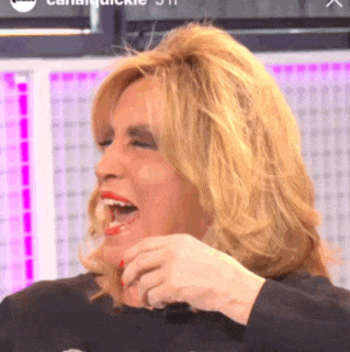 a woman with blonde hair and red lipstick is laughing and covering her mouth with her hand