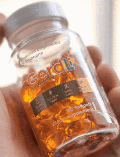 a person is holding a bottle of gerdi dietary supplements