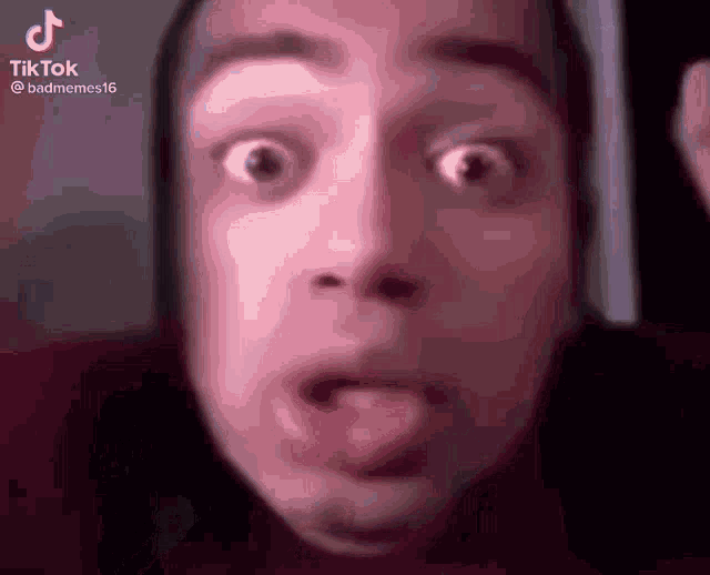 a close up of a person 's face with a surprised look on their face .