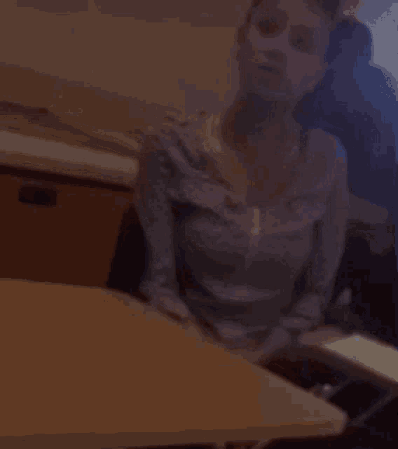a woman is sitting at a table in a blurry photo .