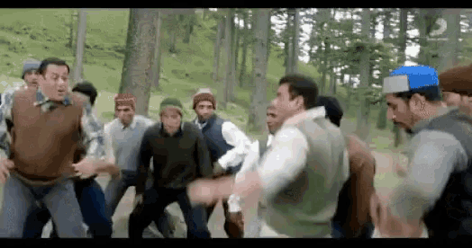 a group of men are dancing in a forest while wearing hats .
