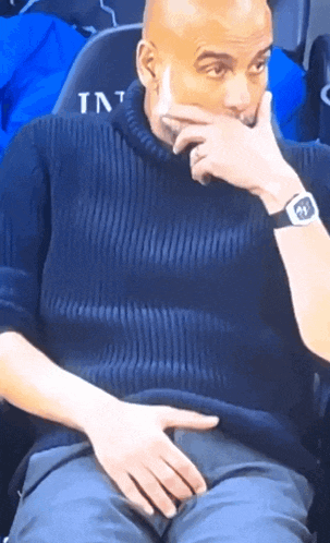 a man wearing a watch and a sweater that says ' int ' on it