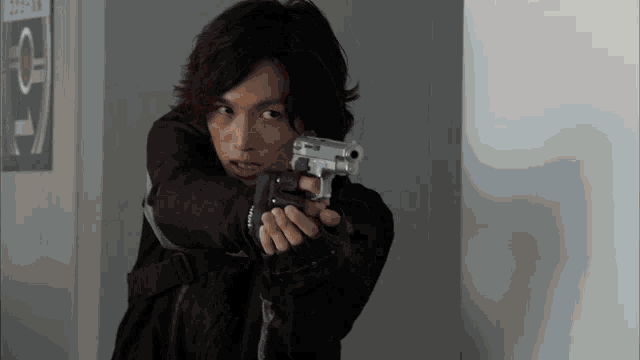 a man in a black jacket is pointing a gun