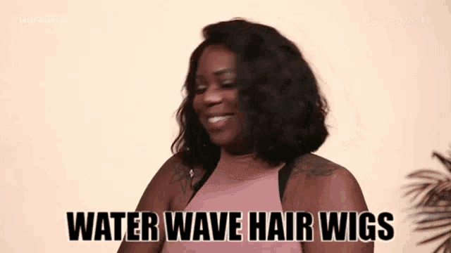 a woman is wearing a pink top and smiling while holding a water wave hair wig .