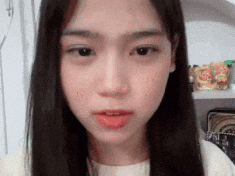 a young woman with long black hair is looking at the camera