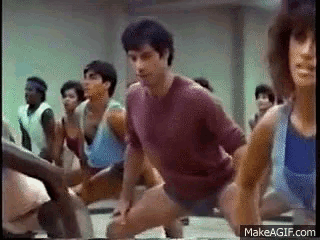 a group of people are dancing together in a gym .