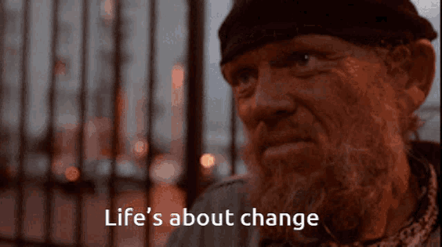 a man with a beard has the words life 's about change above his head