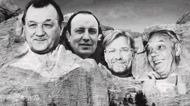 a black and white photo of four men with their faces carved into the rocks