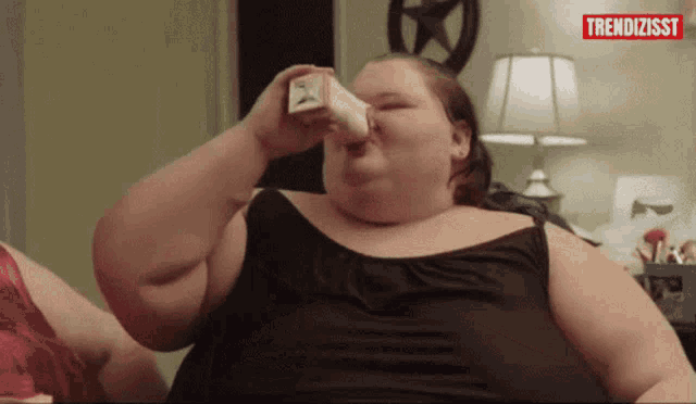 a woman drinking from a bottle with the word trendizsst on the bottom left