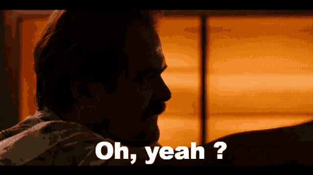 a man with a mustache says " oh yeah " in a dark room