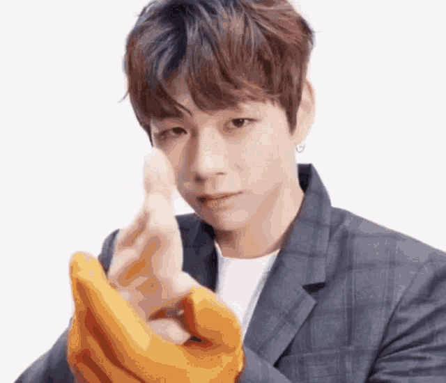 a young man in a suit and gloves is making a heart with his hands .