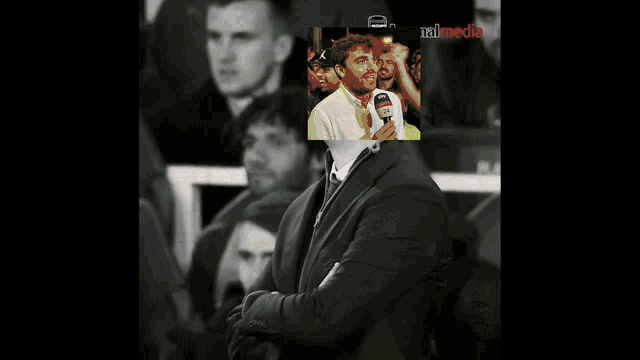 a man in a suit has a picture of a man with a microphone in front of him