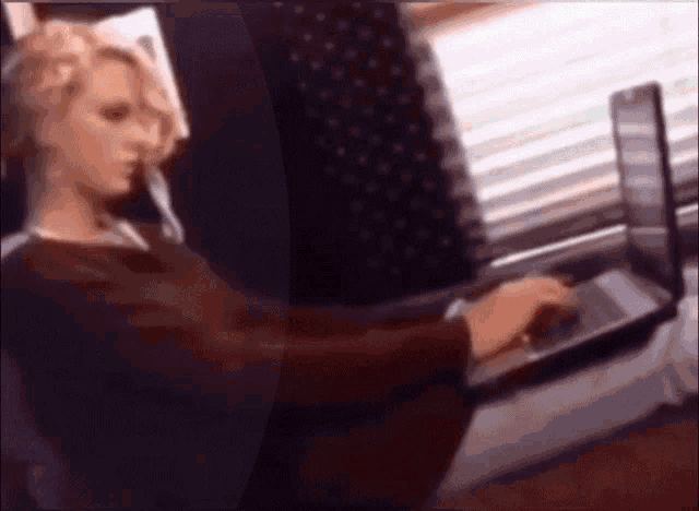 a blurry picture of a woman using a laptop computer