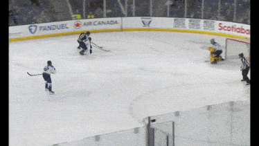 a hockey game is being played on a rink with ads for air canada and scotland