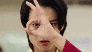 a young man is making a circle with his hand