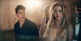 a man and a woman are walking through a dark room .
