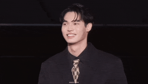 a man in a suit and tie is smiling for the camera with a caption that says ' a ' on it