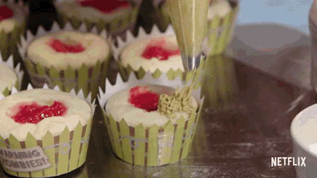 cupcakes with warning zombies written on them are being decorated
