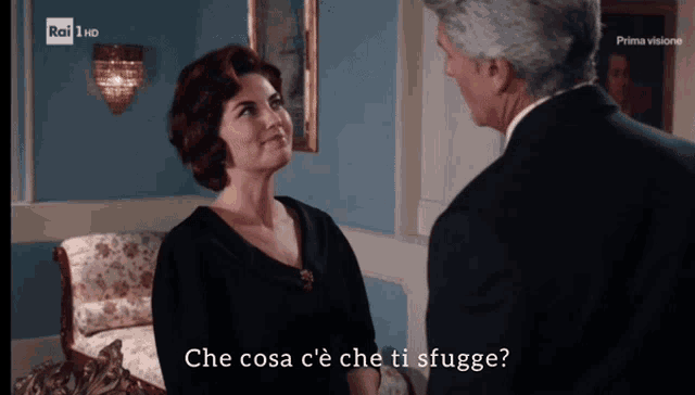 a man and a woman are looking at each other with the words che cosa c ' e che ti sfugge