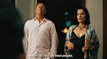 a man and a woman are standing next to each other and the woman is talking about boat people .