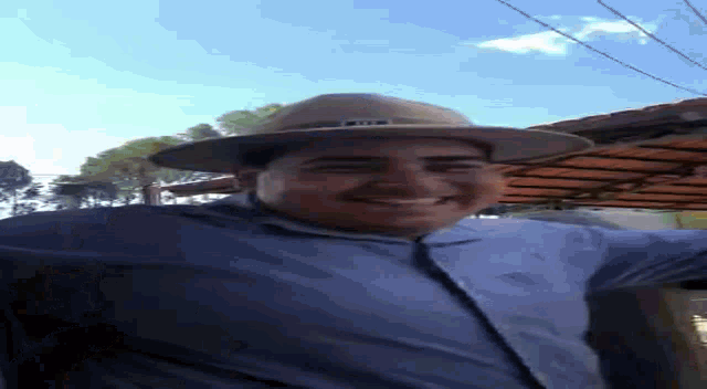 a man wearing a cowboy hat and a blue shirt