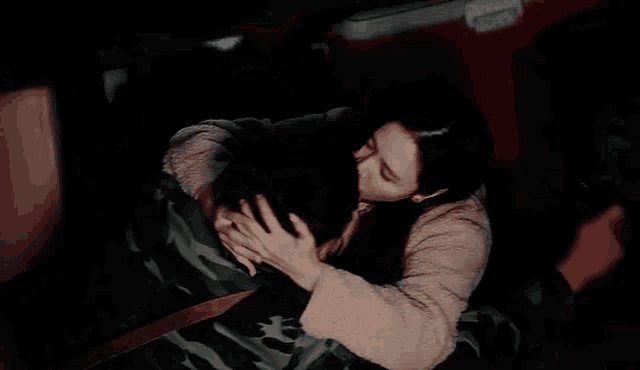 a woman is kissing a man on the cheek in a car .