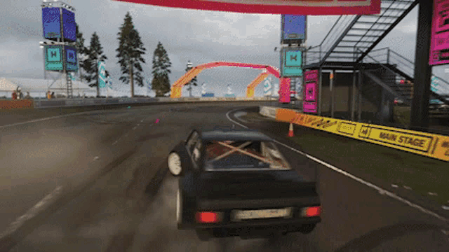 a car is driving down a race track with a sign that says main stage on it